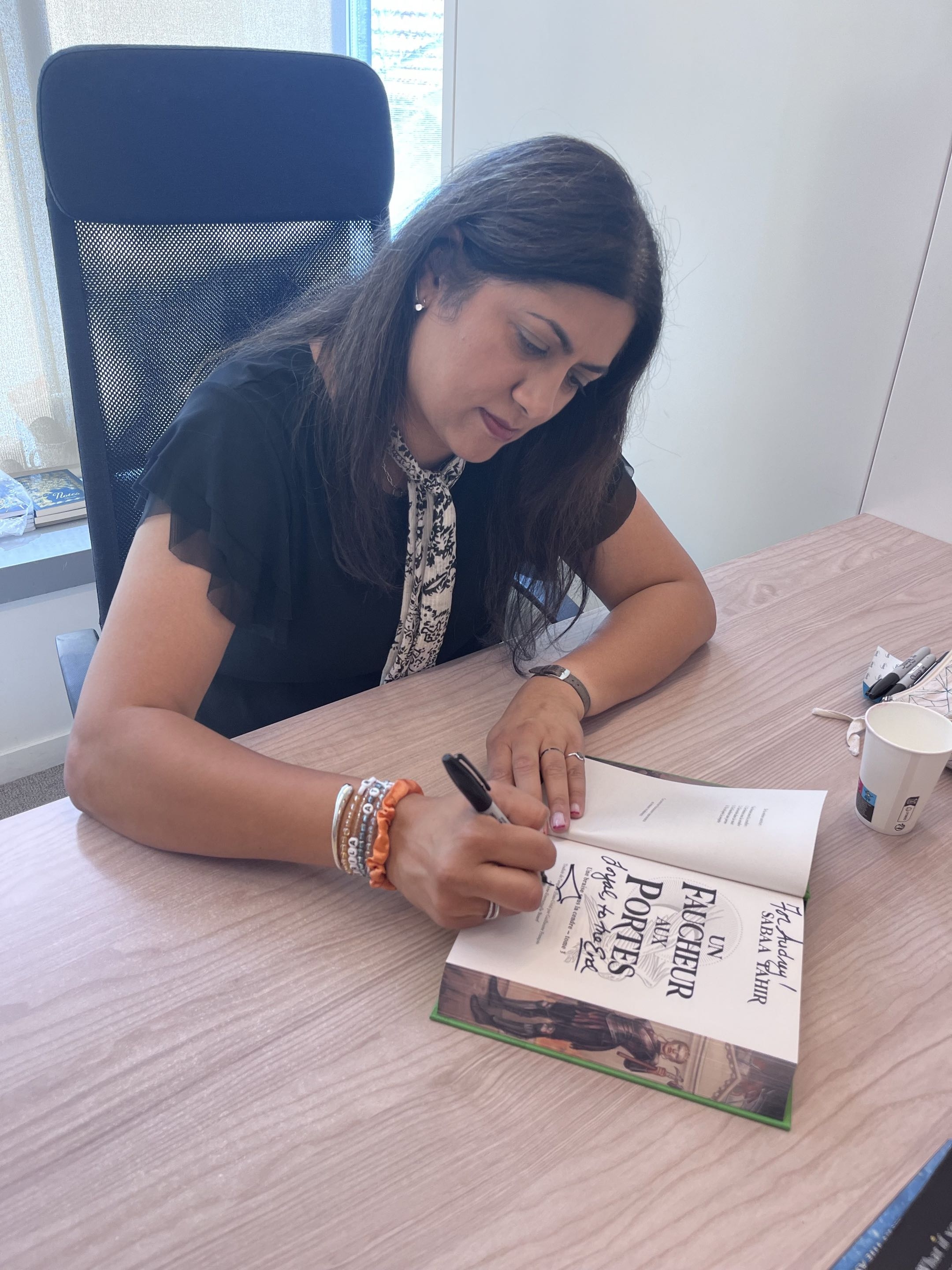 photo de l'autrice en train de signer les livres